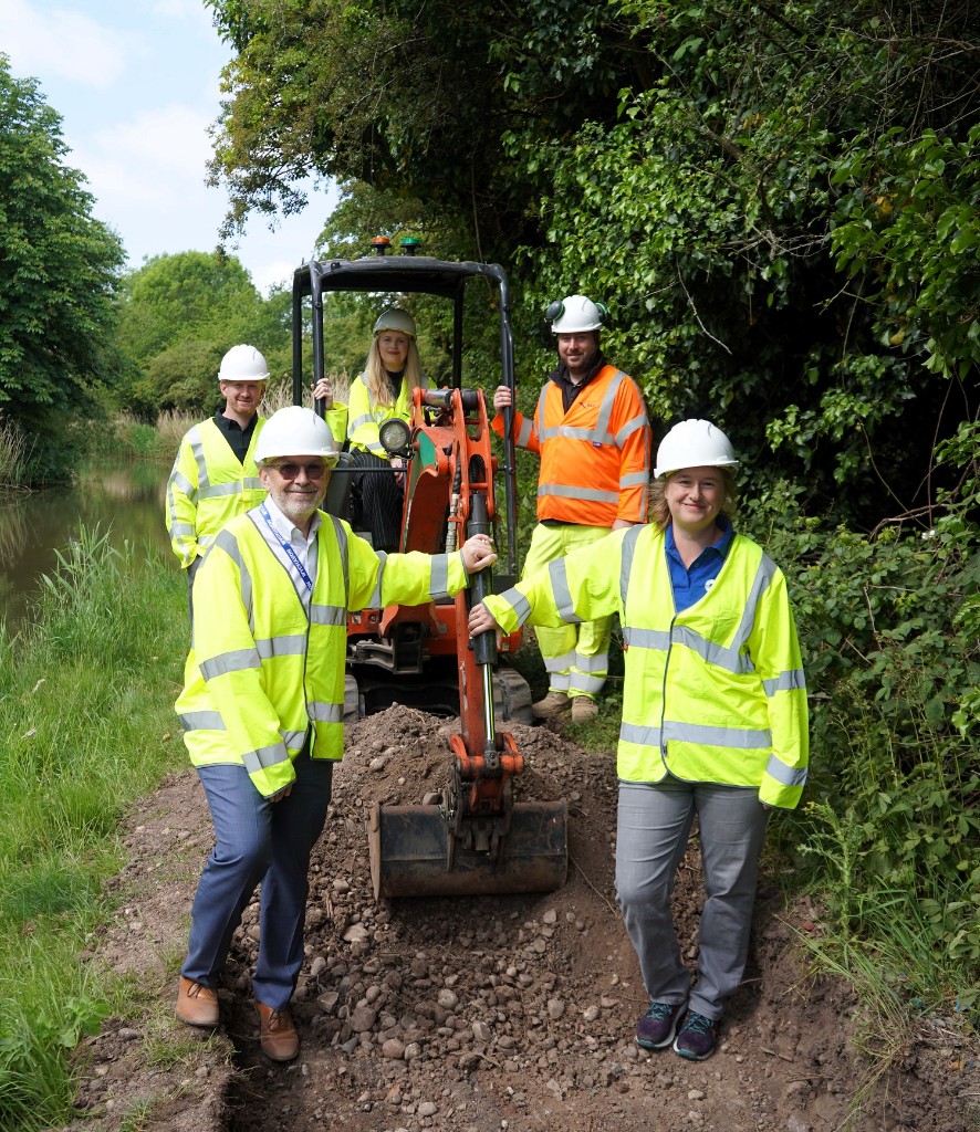 Four people stood around a digger