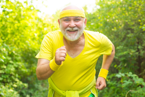 A man wearing a yellow top in a running pose facing the camera