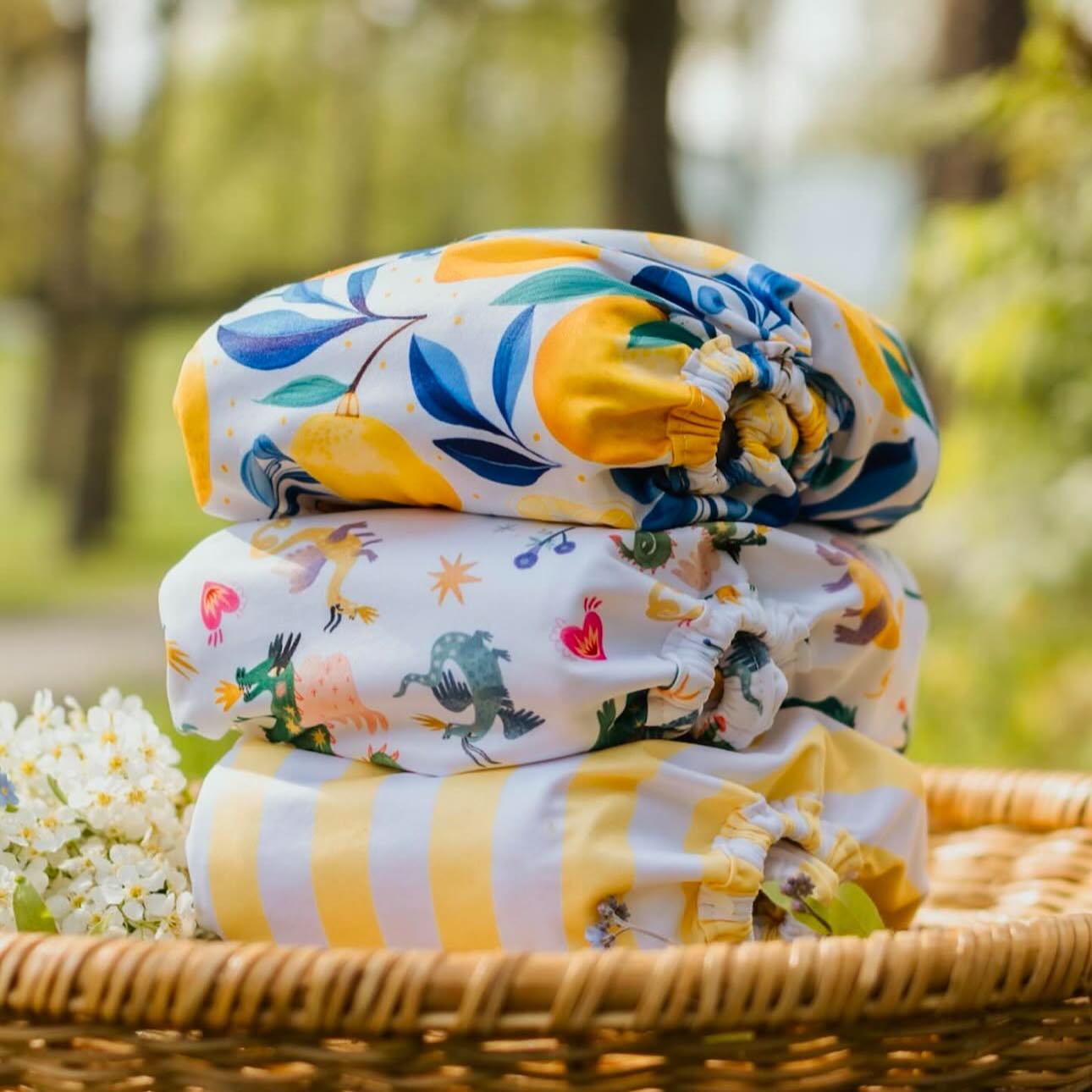 Colourful  image of a stack of a reusable nappies resting in a wicker basket, outside