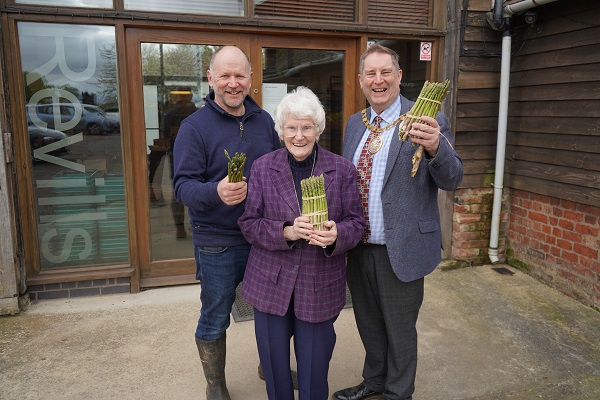 Three people holding asparagus