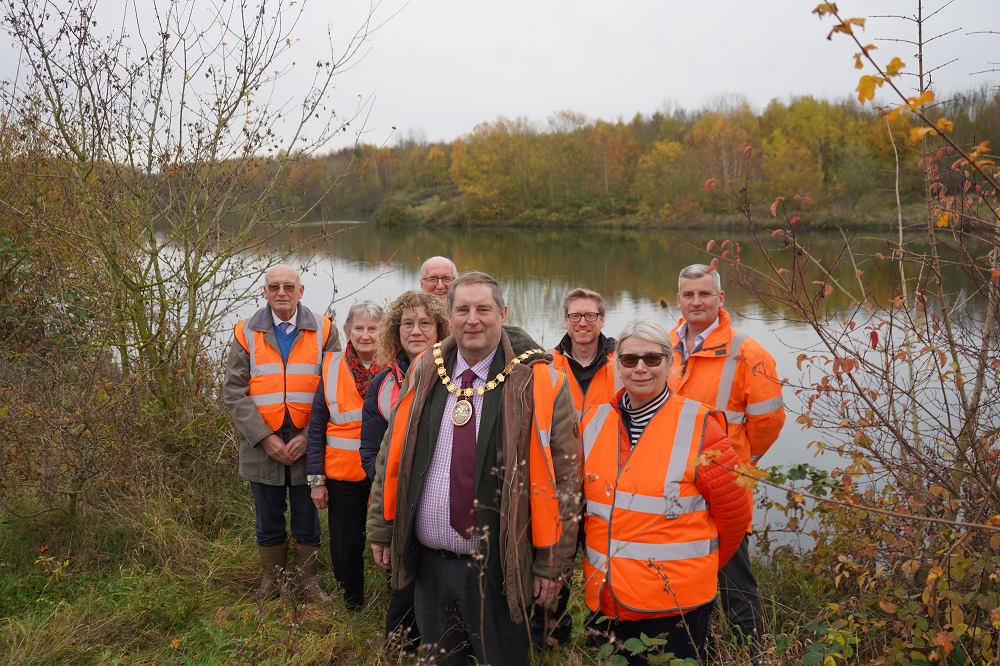 A group of people stood in front of a lake