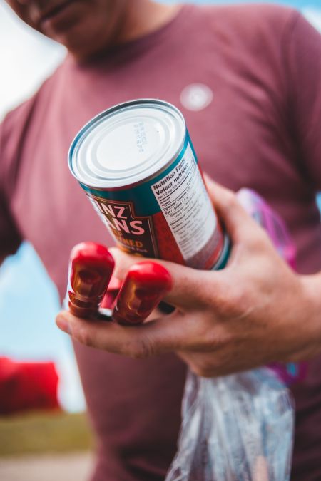 Man holding baked bean tin and can opener