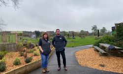 Two people standing at a park