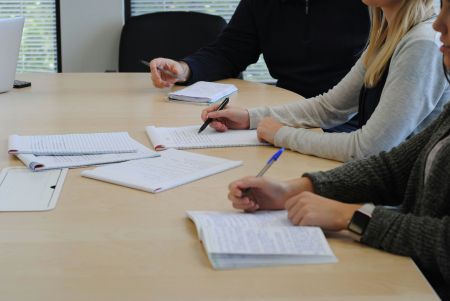 Work colleagues reviewing contract paperwork at a large desk